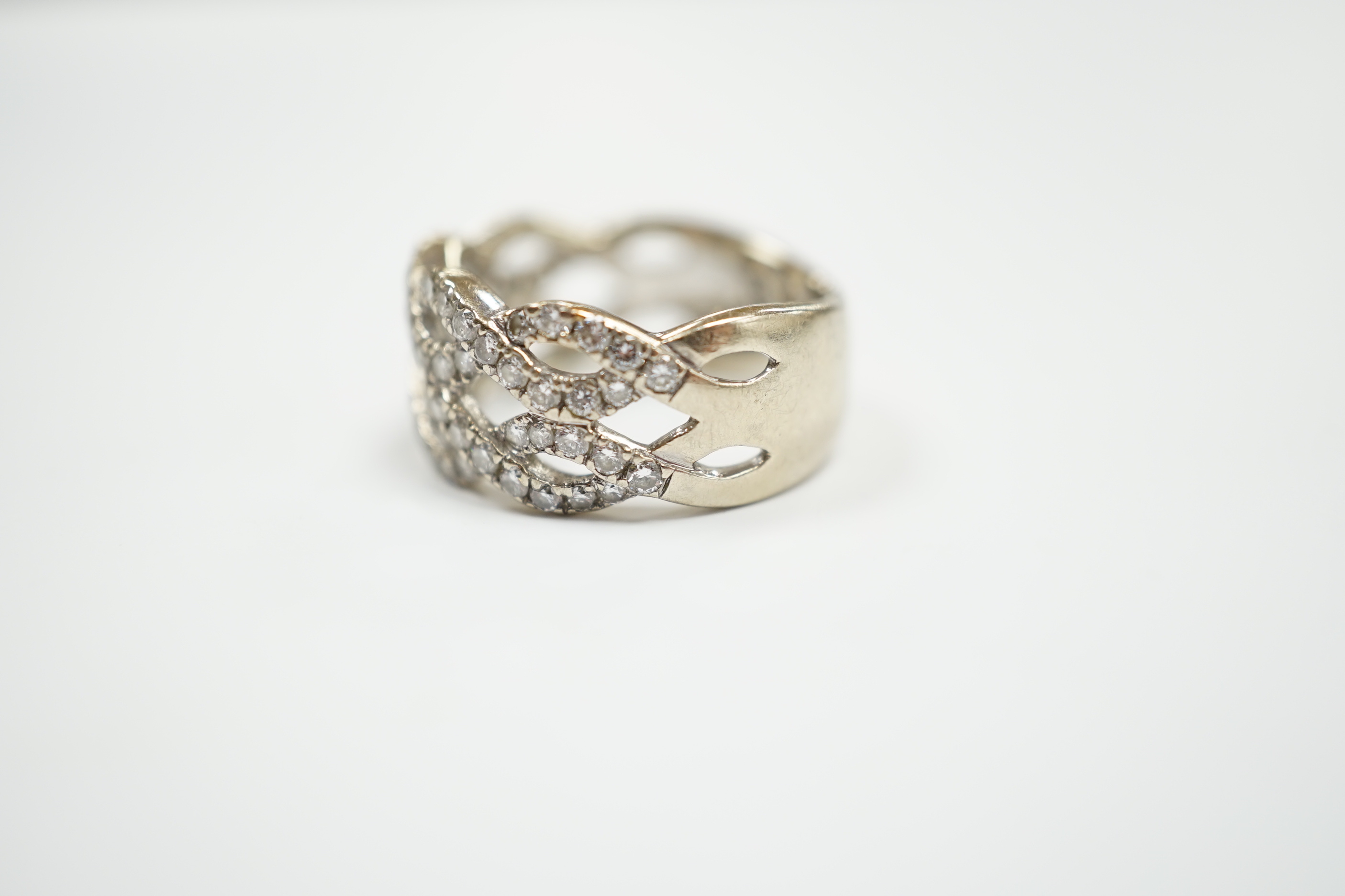 A modern 14k white metal and diamond chip cluster set dress ring, of interwoven design, size M, gross weight 6.4 grams.